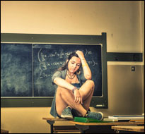 Girl sitting on school desk (iStock)