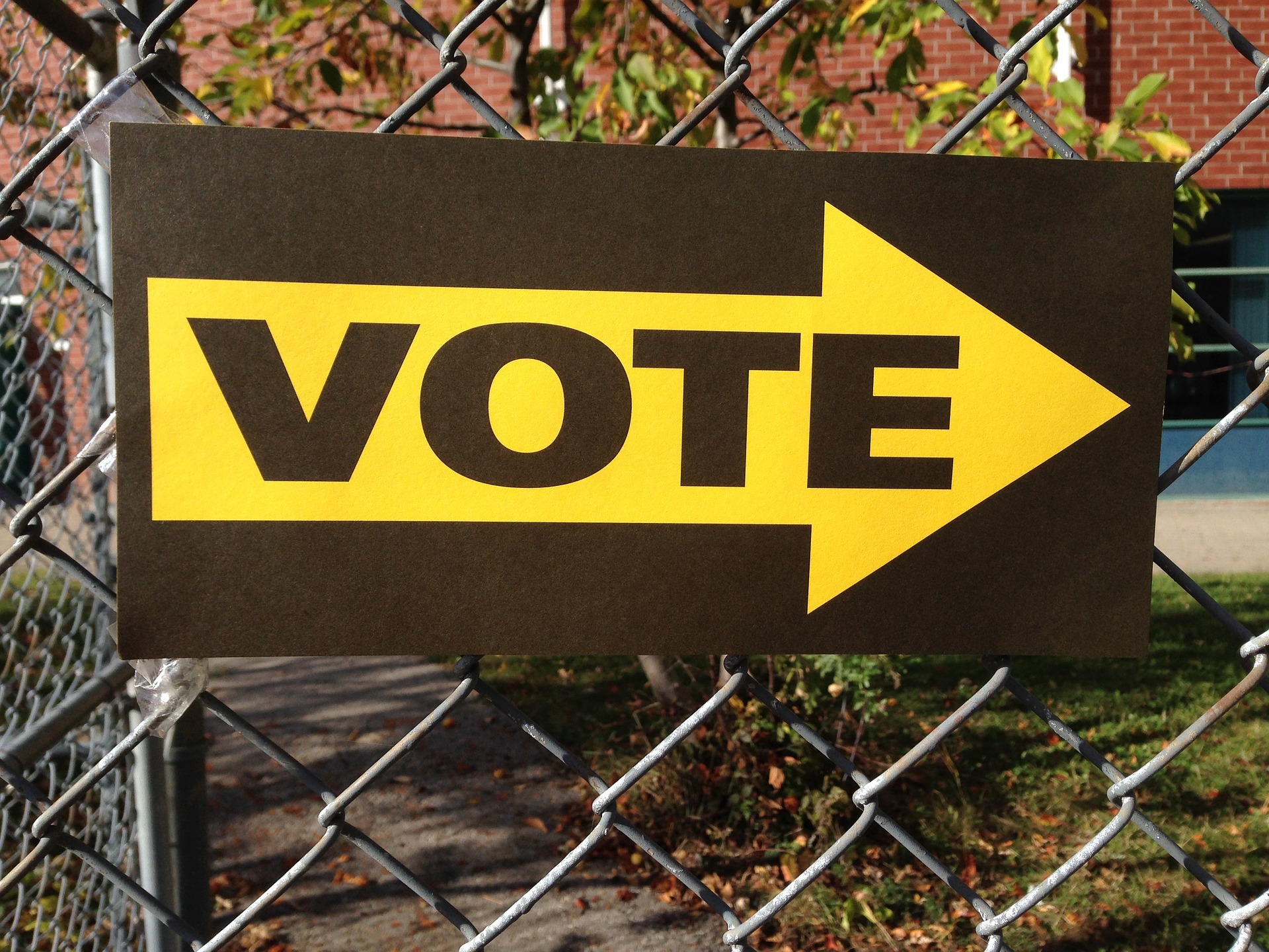 Vote sign hanging on a fence