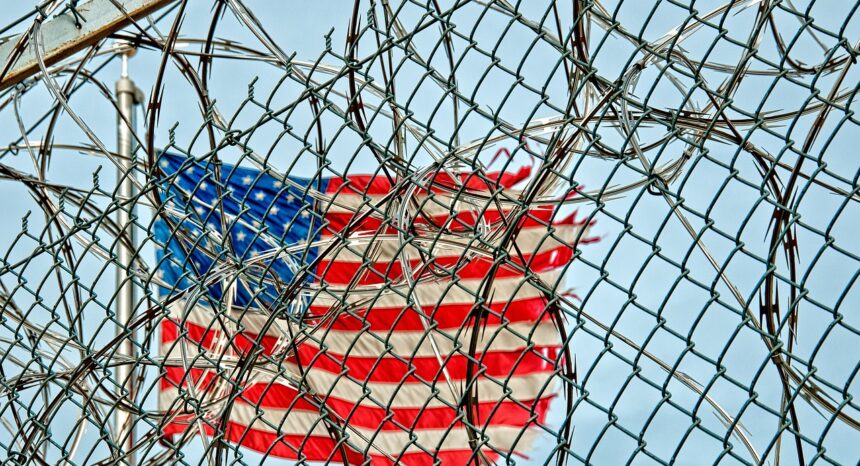 American flag behind a prison fence