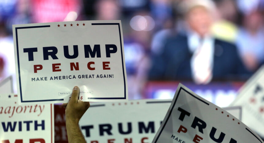 Donald Trump supporters holding signs at a campaign rally