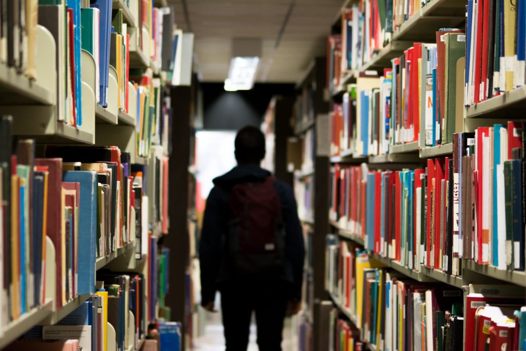 Person standing among library books