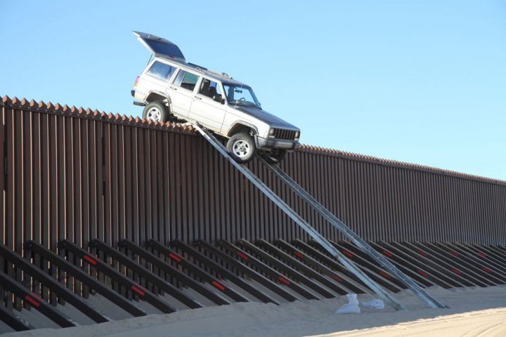 Vehicle stuck on top of a border barrier.