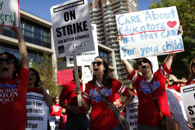 Teachers holding picket signs.