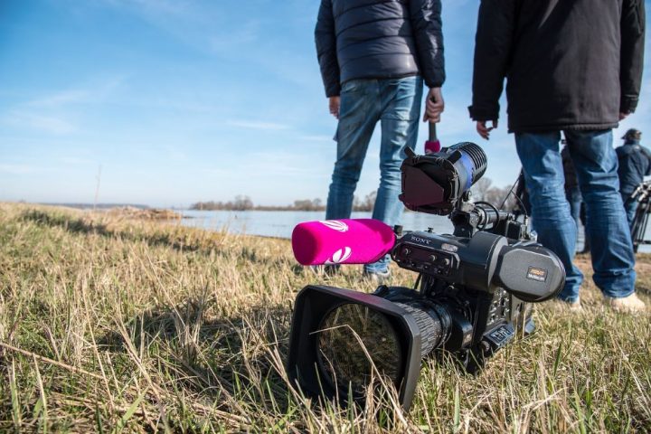 Video camera with two men standing in the background.