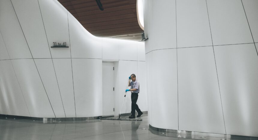 A janitor sweeps in the lobby of a large office building