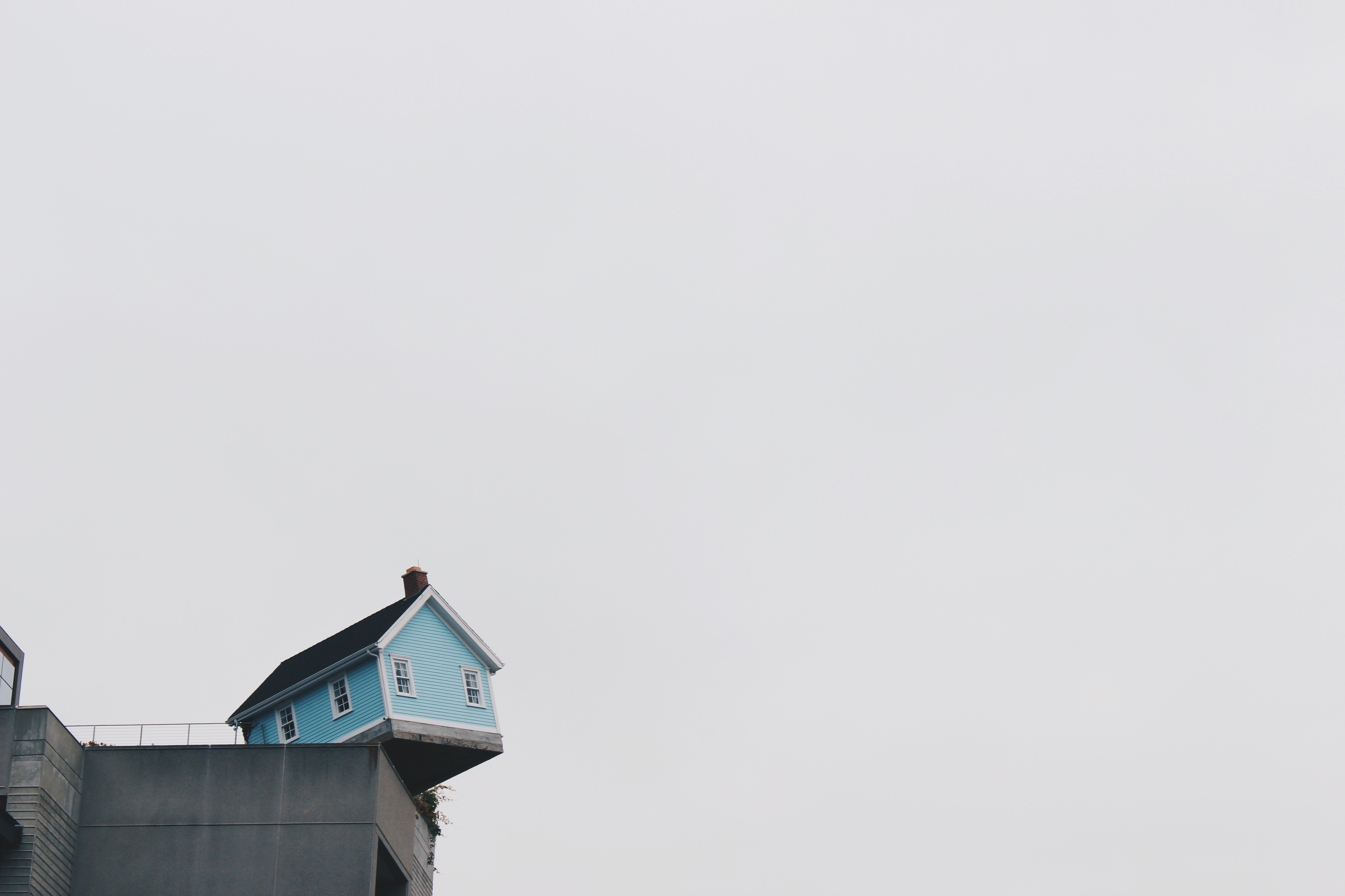 Image of a blue house on the edge of a concrete structure.