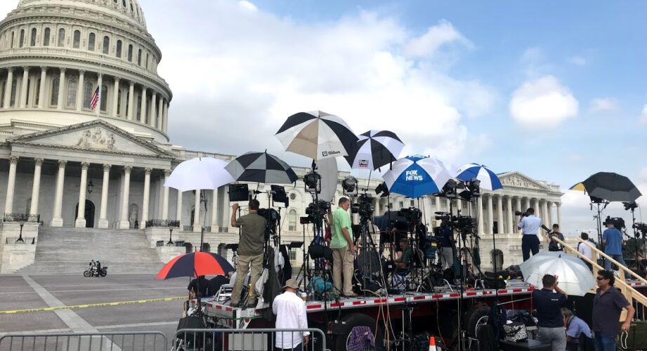 News teams set up before press conference in front of Capitol Hill