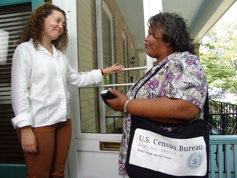 Photo of census worker speaking with a resident.