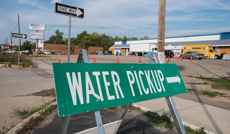 A green street sign reads water pickup with an arrow pointing to the location.