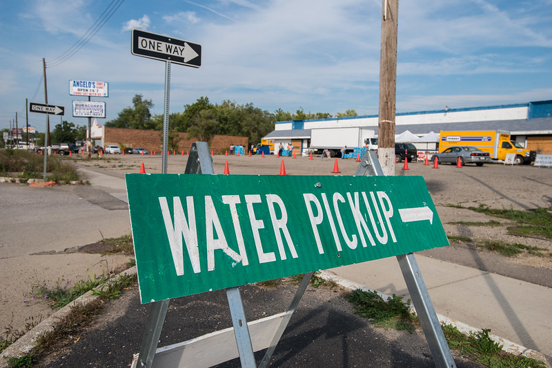 A green street sign reads water pickup with an arrow pointing to the location.