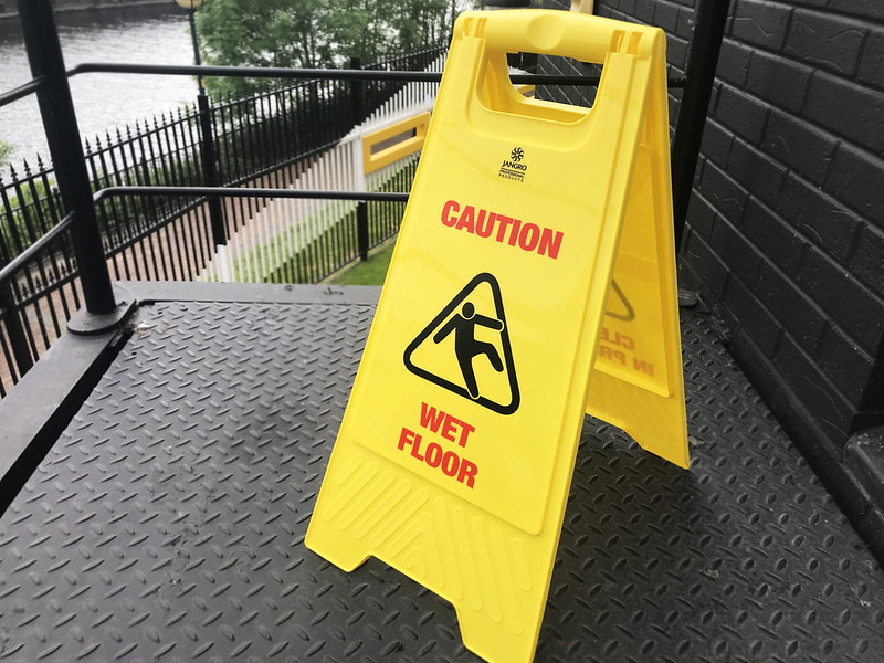 A yellow warning sign that reads, "caution, wet floor."